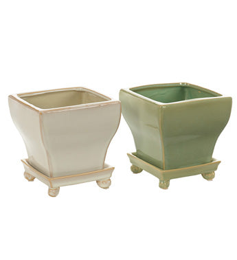 Two ceramic planters, one beige and one green, on a white background