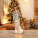 Porcelain light up angel on table with christmas tree in the background