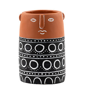 Ceramic vase with face design and black and white pattern on a white background