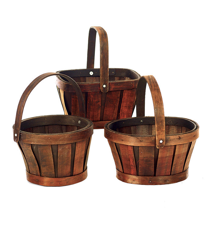 Three dark wooden baskets with handles on a white background